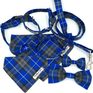 Peut inclure: Un ensemble collier, laisse, bandana et n&oelig;ud papillon pour chien en tissu &eacute;cossais bleu et gris. L'ensemble est orn&eacute; d'une bordure jaune et blanche et du texte "Barkley & Fitch" sur le bandana et le collier.