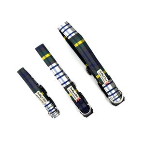 May include: Three dog collars in varying sizes, featuring a plaid pattern in navy, green, yellow, and white. Each collar has a silver metal ring and a black buckle. The collars are labeled "Barkley & Fitch Canine Outfitters".