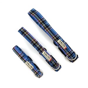 May include: Three dog collars in different sizes, patterned with blue, pink, and yellow plaid. Each collar has a silver metal D-ring and a label that reads "Barkly & Fitch CANINE OUTFITTERS".