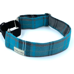 May include: A blue and grey plaid dog collar with a black nylon strap and silver buckle. The collar has the text "Barkley & Fetch Canine Outfitters" on it.