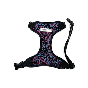 May include: Black dog harness with a pink and blue paisley pattern. The harness has a label that reads "Barkley & Fetch Canine Outfitters".