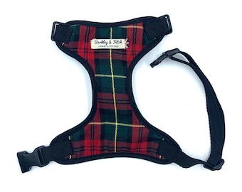 May include: A black dog harness with a red, green, and yellow plaid pattern. The harness has a label that reads "Barkley & Fetch Canine Outfitters".
