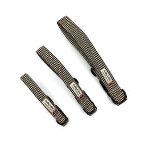 May include: Three dog leads in different lengths, patterned with a brown and cream houndstooth design. Each lead has a black metal ring and a label reading "Barkly & Fitch CANINE OUTFITTERS" with a small Union Jack flag.