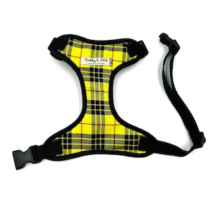 May include: Yellow and black tartan dog harness with a black adjustable strap and a black buckle. The harness has a label that reads "Barkley & Fetch Canine Outfitters".