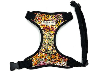 Peut inclure: Harnais pour chien à motifs floraux aux tons jaune, orange et violet, avec bordure et sangles noires. Le harnais est doté de sangles réglables et d'une fermeture à boucle. La marque "Barkley & Fitch" est imprimée.