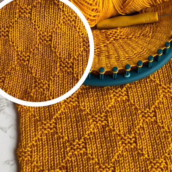 May include: A close-up of a yellow knitted fabric with a diamond pattern. The fabric is being knitted on a circular knitting loom.