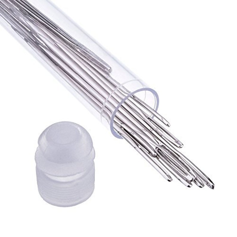 May include: A clear plastic tube filled with a bundle of silver sewing needles. The tube has a white plastic cap on one end.