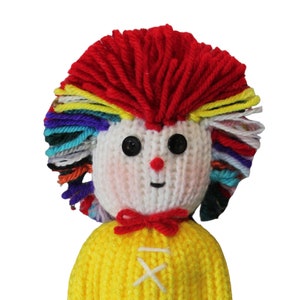 May include: A knitted doll with a yellow shirt, red bow, and colorful yarn hair.