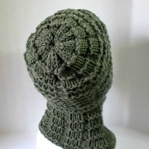 May include: A green knitted hat with a unique textured pattern. The hat has a folded brim and a slouchy fit.