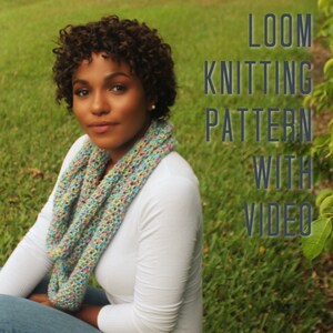 May include: A woman wearing a white shirt and blue jeans is wearing a colorful knitted scarf. The text "LOOM KNITTING PATTERN WITH VIDEO" is superimposed on the image.
