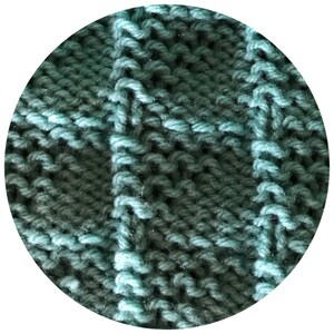 May include: Close-up of a knitted fabric with a textured, grid-like pattern. The yarn is a blend of teal and dark teal, creating a subtle color gradient. The stitches are clearly defined, showcasing the craftsmanship of the knit.
