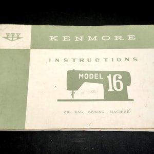 May include: A rectangular instruction manual for a Kenmore Model 16 zig-zag sewing machine. The cover is white and sage green with a graphic of a sewing machine and the text KENMORE INSTRUCTIONS MODEL 16 ZIG-ZAG SEWING MACHINE printed on it.