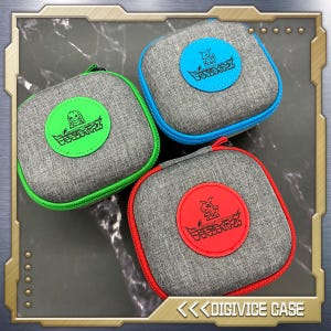 Puede incluir: Tres estuches de tela gris con detalles coloridos. Cada estuche tiene un parche circular con un personaje de dibujos animados y texto japonés. Los estuches tienen cremalleras y ribetes de colores en verde, azul y rojo. El texto "DIGIVICE CASE" está en la parte inferior.