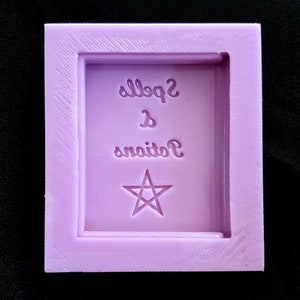 May include: A purple silicone mould for making resin crafts. The mould is shaped like a book with the words "Potions & Spells" and a pentagram star.