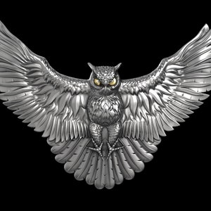 May include: A silver owl sculpture with outstretched wings. The owl has yellow eyes and detailed feathers.