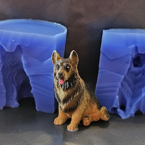 May include: Two blue silicone molds for making a German Shepherd dog figurine. The molds are shown with a small, brown and black German Shepherd dog figurine.