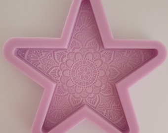 May include: A light purple silicone mold shaped like a star with a mandala design inside.