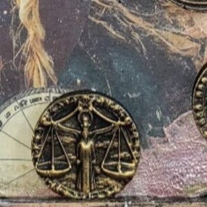 K&ouml;nnte beinhalten: Ein Satz von zw&ouml;lf goldfarbenen Tierkreiszeichen, die jeweils ein anderes astrologisches Symbol darstellen. Die Zeichen sind in einem Kreis auf einem Hintergrund mit einem himmlischen Design angeordnet.