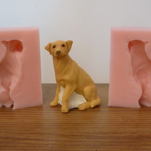 May include: Two pink silicone molds for casting a dog figurine. The molds are open and show the dog's shape. A brown dog figurine is in the center of the image.