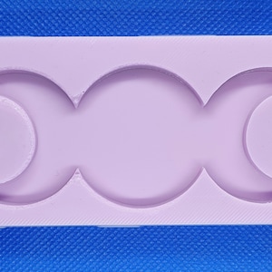 May include: A light purple silicone mold with three crescent moon shapes. The mold is designed for making resin crafts.