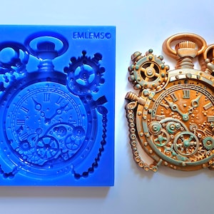 Op de afbeelding: Een blauwe siliconen mal voor het maken van een steampunk-stijl zakhorloge met ingewikkelde tandwielen en een ketting. De mal is gemarkeerd met "EMLEMSO".