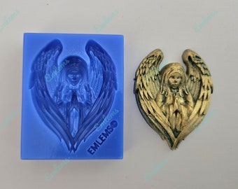 May include: A silicone mold for making resin crafts. The mold is blue and features a detailed design of a praying angel with wings. The mold is labeled "EMLEMSO".