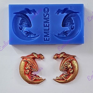 May include: A blue silicone mould featuring two dragon and crescent moon designs, and two finished dragon moon pendants in gold and red. The mould has the text "EMLEMSO" printed on it.