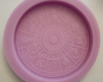 May include: A purple silicone mold with a zodiac wheel design. The mold features the twelve zodiac signs and their symbols, including Aries, Taurus, Gemini, Cancer, Leo, Virgo, Libra, Scorpio, Sagittarius, Capricorn, Aquarius, and Pisces.