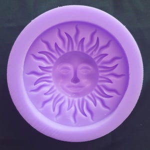 May include: Purple silicone mould shaped like a sun with a smiling face.