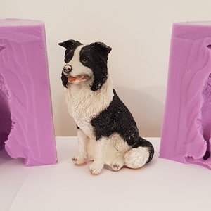 May include: Two purple silicone molds for making a border collie dog figurine. The molds are open and show the inside of the mold, which is shaped like a dog. A finished border collie figurine is in the center of the image.