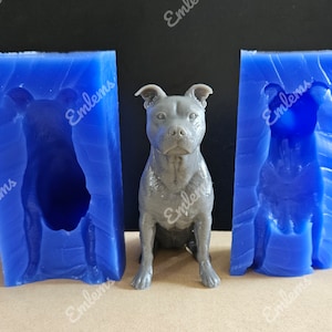 Könnte beinhalten: Zwei blaue Silikonformen zum Herstellen einer Staffordshire Bull Terrier Hundefigur. Die Formen sind rechteckig und haben eine strukturierte Oberfläche. Die Hundefigur ist grau und steht in der Mitte des Bildes.