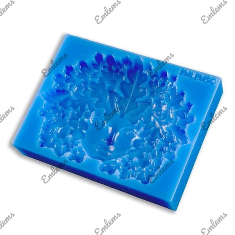 May include: Blue silicone mold with a detailed design of a tree with leaves and a bird inside. The mold is for making decorative items like cake toppers or soap.