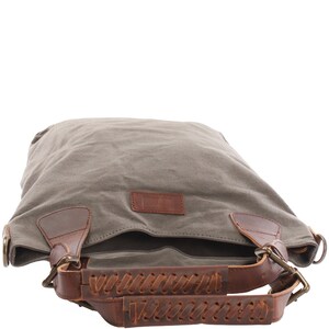May include: A gray canvas tote bag with brown leather straps and braided handles. The bag has a brown leather patch with the word "Linen" on it.