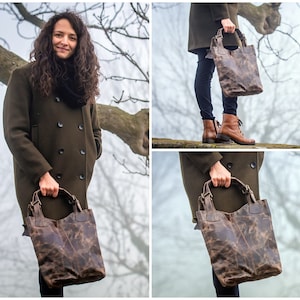 May include: A brown leather tote bag with a distressed finish. The bag has two top handles and a zipper closure.