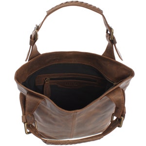 May include: Brown leather tote bag with a braided handle and a zippered pocket inside. The bag has a buckle closure on the straps.