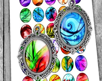 May include: Two oval silver-toned metal pendants with intricate filigree borders, each containing a glass cabochon with abstract colorful patterns. These pendants are displayed over a sheet of matching oval-shaped paper stickers.