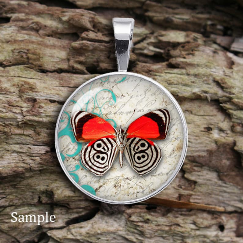 May include: A silver pendant with a round glass cabochon featuring a red and black butterfly on a vintage background with turquoise accents.