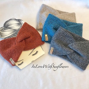 May include: Four knitted headbands in different colors: rust, teal, gray, and beige. Each headband has a knotted design and a small leather tag with the text "In Love With Sunflowers".
