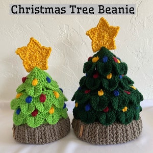 May include: Two crocheted Christmas tree beanies with brown brims. The beanies are green with yellow, red, and blue ornaments. The larger beanie has a yellow star on top.