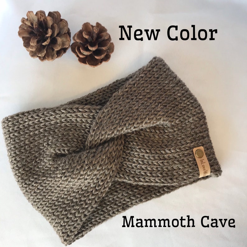 May include: A brown knitted headband with a knotted design. The headband has a small brown leather tag with the text "InLoveWith" on it. The text "New Color" and "Mammoth Cave" are also visible in the image.