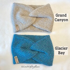 May include: Two knitted headbands in a twisted style. The top headband is a light beige color and says "In Love With" on the label. The bottom headband is a teal blue color and says "In Love With" on the label. The text "Grand Canyon" is written in black above the top headband and the text "Glacier Bay" is written in black above the bottom headband.
