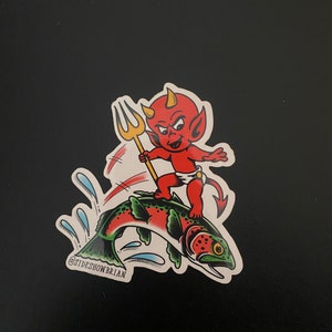 May include: A red devil with horns and a tail riding a green, red, and white fish with a trident in hand. The fish is jumping out of the water and there are blue water splashes around it. The image has the text "@SIDESHOWBRIAN" at the bottom.