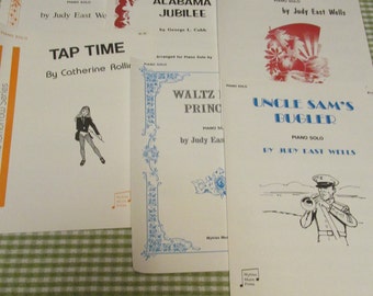 May include: Four sheet music covers for piano solos. The covers are white with blue and red accents. The titles are "Peach Jam", "Alabama Jubilee", "Echoes of Dawn", and "Uncle Sam's Bugler".