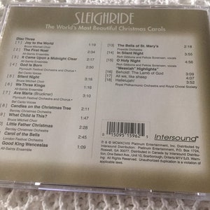 May include: A CD case with a gold background and the title "Sleighride: The World's Most Beautiful Christmas Carols". The back of the case lists the songs on the CD, including "Joy to the World", "The First Noel", "It Came Upon a Midnight Clear", "God Is Born", "Silent Night", "We Three Kings", "Ave Maria", "Candles on the Christmas Tree", "What Child Is This?", "Little Father Christmas", "Carol of the Bells", and "Good King Wenceslas".