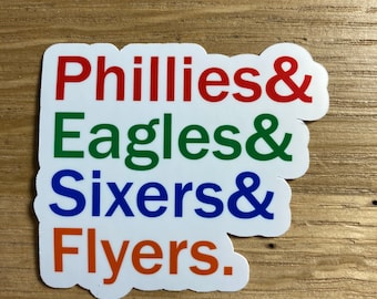 May include: A white sticker with the words "Phillies & Eagles & Sixers & Flyers" in red, green, blue, and orange.