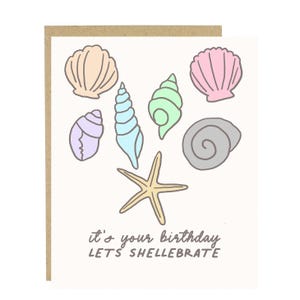 May include: A white card with a colorful illustration of seashells and a starfish. The text on the card reads "it's your birthday LET'S SHELLEBRATE".
