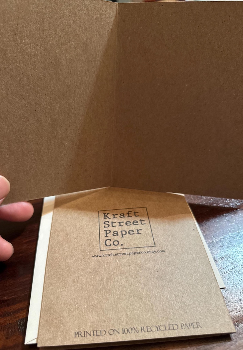 May include: Kraft Street Paper Co. logo printed on a brown card with the text "Printed on 100% Recycled Paper" at the bottom. The website address is www.kraftstreetpaperco.etsy.com.