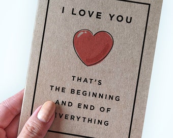 May include: A brown card with a black border and the text "I love you. That's the beginning and end of everything."  A red heart is drawn in the center of the card.