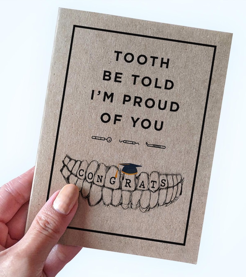 May include: A brown card with the text "Tooth be told I'm proud of you" and a drawing of a set of teeth with a graduation cap on one of the teeth. The text "Congrats" is written on the teeth.