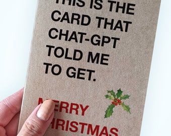 May include: A brown card with the text "THIS IS THE CARD THAT CHAT-GPT TOLD ME TO GET." and "MERRY CHRISTMAS" in red text with a small green holly sprig with red berries.